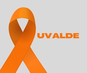 Image of an orange ribbon with the word UVALDE in the center of the rectangular image.