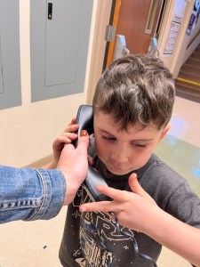 A kindergarten boy speaks on the school phone.