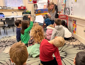 I am reading to my kindergarten class. Kids look at book. 