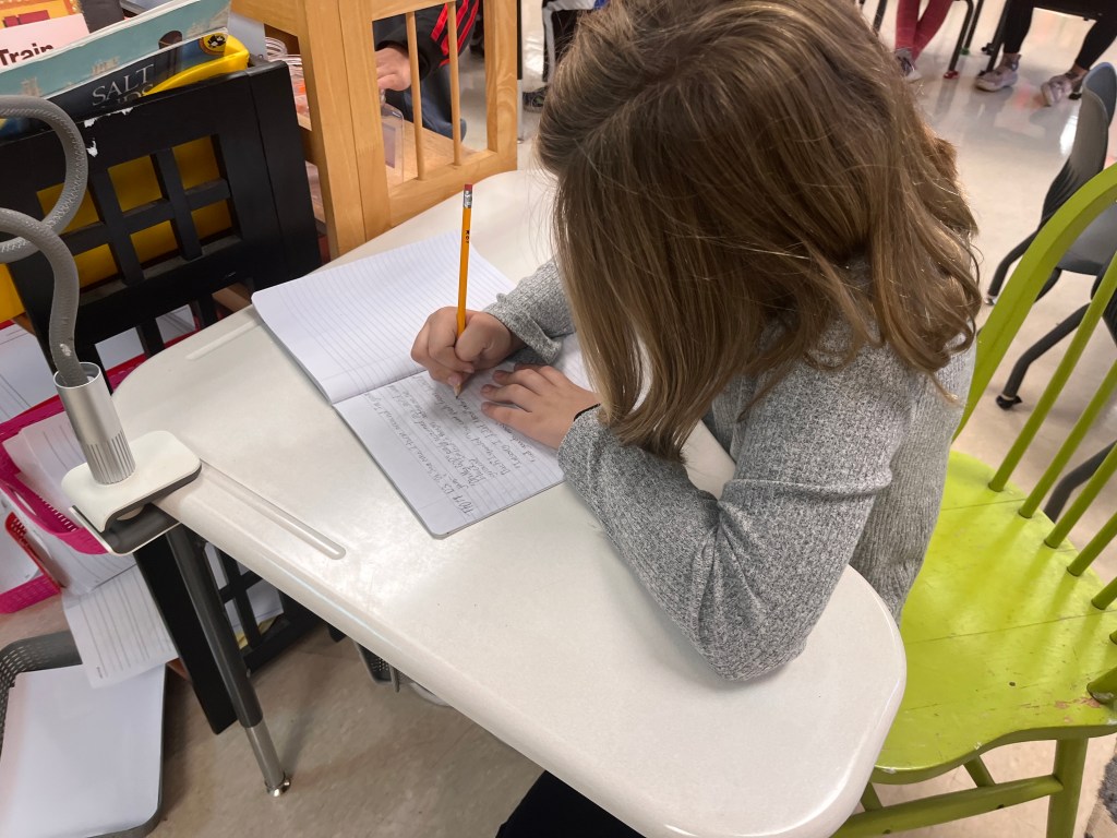 This fifth grader opted to sit in a quiet spot alone as she revised a piece in her writer's notebook that she started in class.