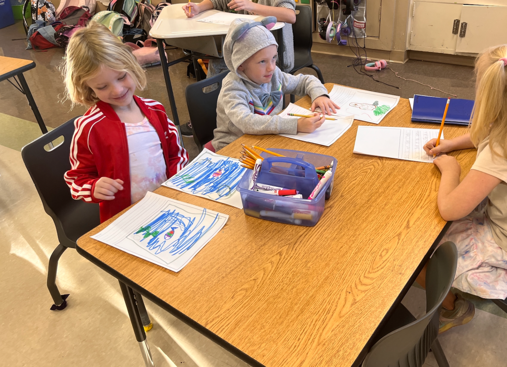 First and second graders chat as they work on their independent writing projects.