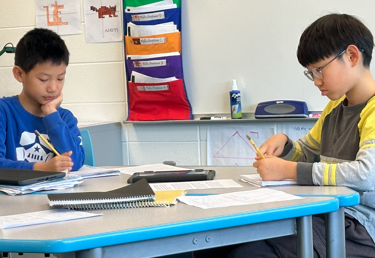 Students writing at a table