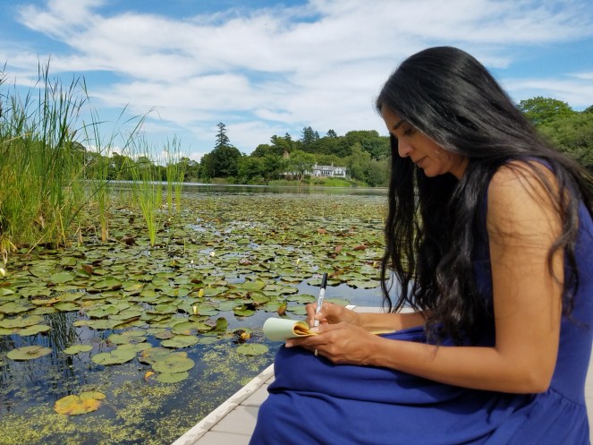 Padma Venkatraman writing along the dock by the water
