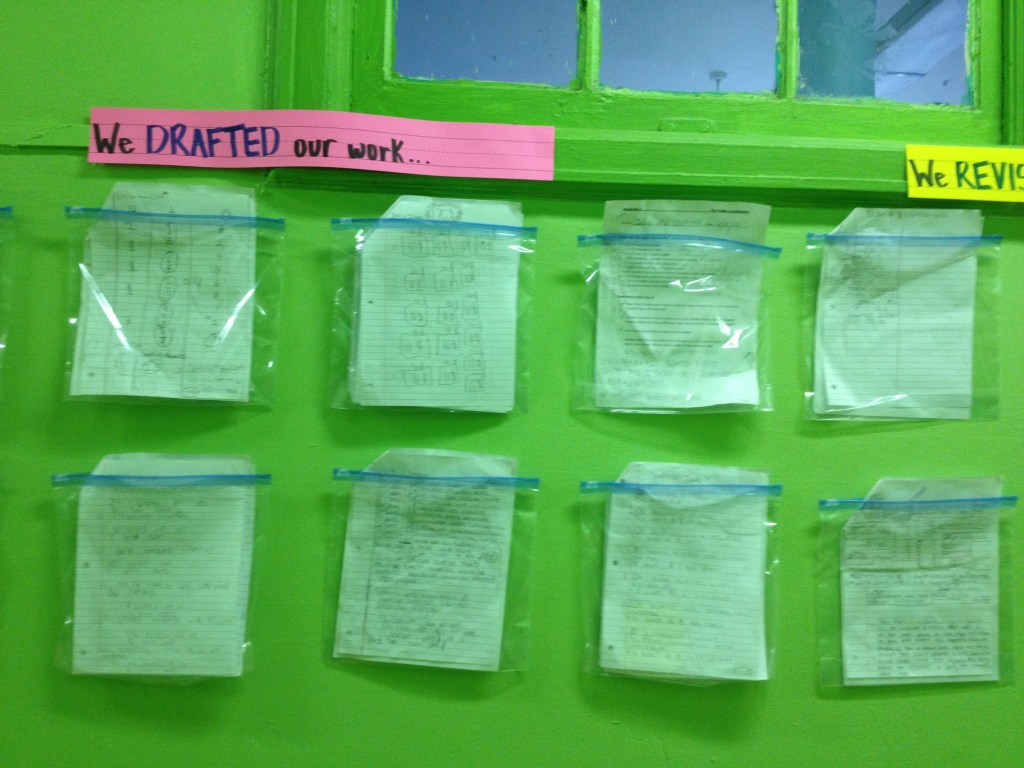 An image of a bulletin board displaying student work with the heading, "We drafted our work..."