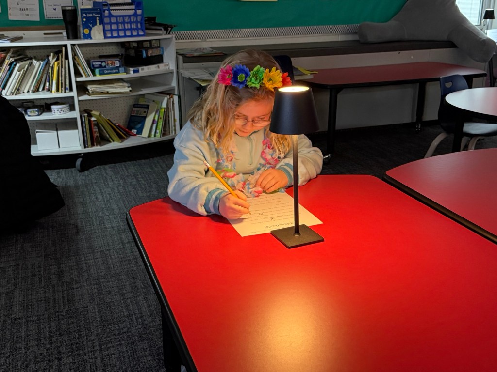Student writing at desk